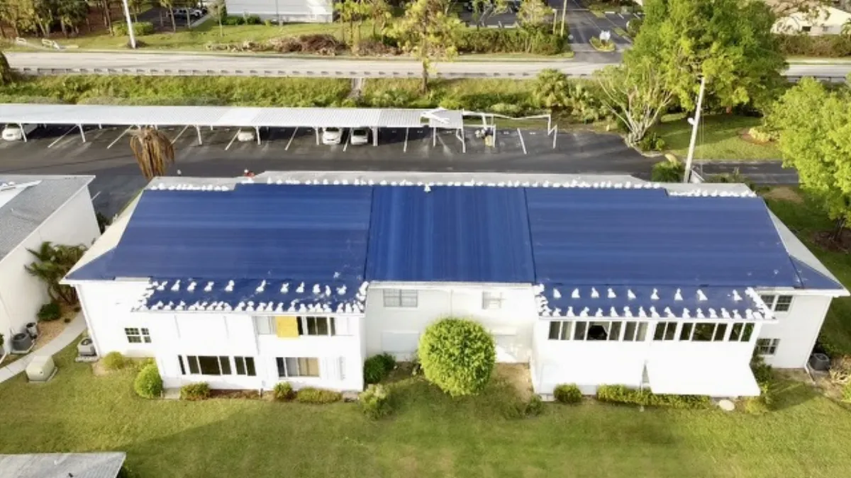 Aerial view of blue emergency tarp on commercial building